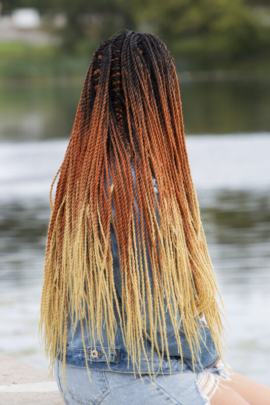 dame mit ombre braids in schwarz und rot und gelb